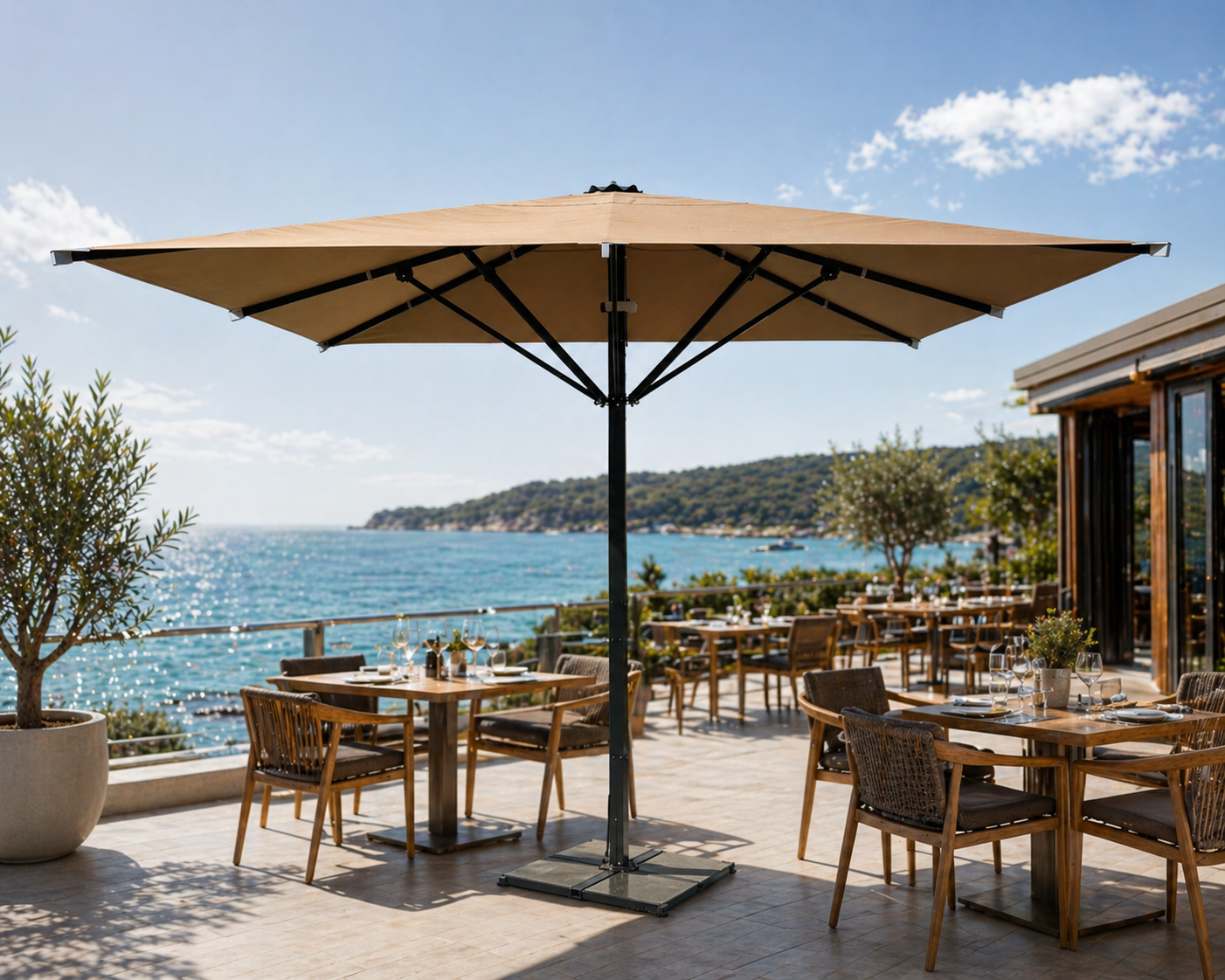 Kronenschirme am Meer mit Liegen und Hotelanlage